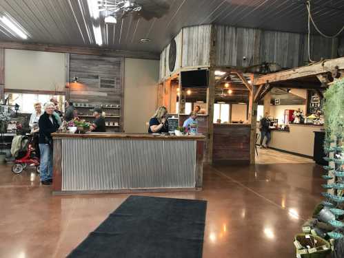 A rustic interior of a shop with a reception area, wooden decor, and customers browsing around.