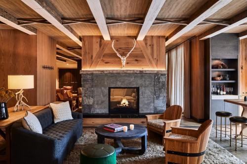 Cozy living room with a stone fireplace, wooden beams, and stylish furniture, creating a warm, inviting atmosphere.