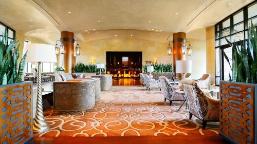 Elegant hotel lobby featuring plush seating, decorative plants, and warm lighting, creating a welcoming atmosphere.