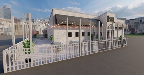 A modern restaurant with a spacious outdoor patio, surrounded by a white fence and city skyline in the background.
