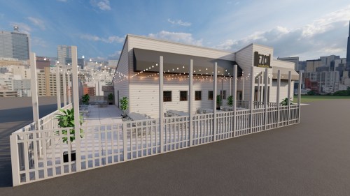 A modern building with a patio, surrounded by a white fence, set against a city skyline under a blue sky.