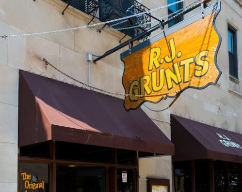 Exterior of R.J. Grunts restaurant featuring a large sign and awnings, with a menu displayed near the entrance.