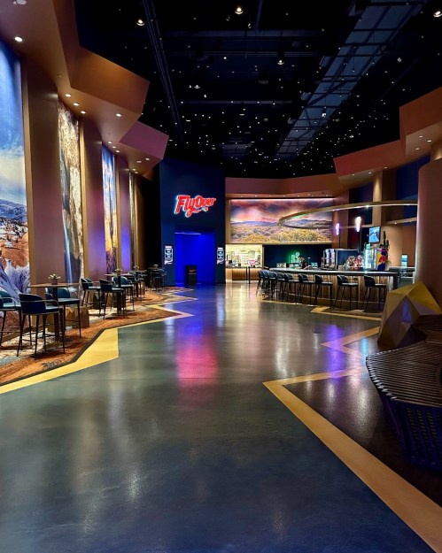 Interior of a modern entertainment venue with colorful walls, bar seating, and a vibrant atmosphere.