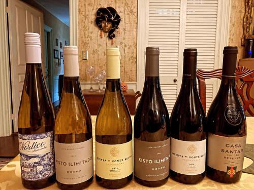 A collection of seven wine bottles displayed on a table, featuring various labels and styles.