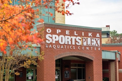 Sign for Opelika SportsPlex and Aquatics Center, framed by autumn leaves.
