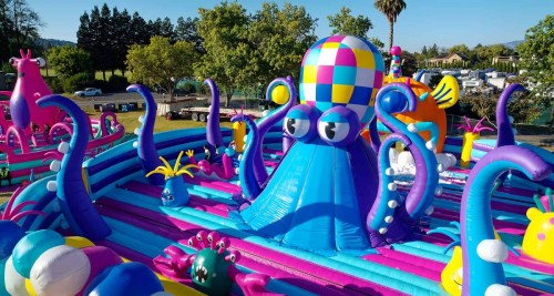 A colorful inflatable playground featuring a large octopus and various whimsical sea creatures.