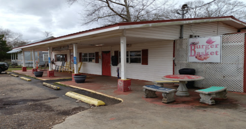 A small, casual restaurant called "Burger Basket" with outdoor seating and a covered entrance.