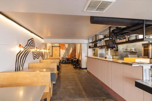 Interior of a modern restaurant featuring wooden booths, a sleek counter, and abstract wall art.