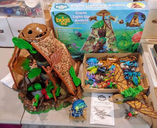 A colorful toy set featuring a giant light-up anthill, various insects, and a box labeled "A Bug's Life."