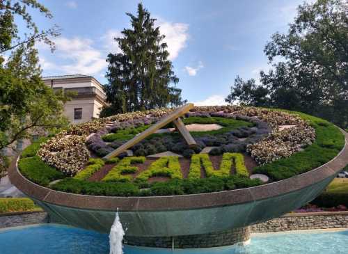 A large floral display shaped like a clock, featuring the word "TEAM" in vibrant flowers, surrounded by greenery.