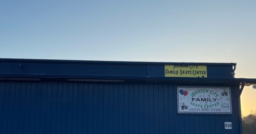 Signage for Johnson City Family Skate Center on a blue building, with a clear sky in the background.