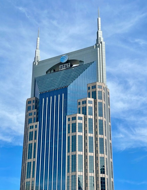 AT&T building with a modern design, featuring a glass facade and spires, against a blue sky.