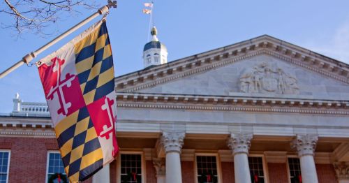 outside of the Maryland state capital building in Annapolis, Maryland next to the state flag