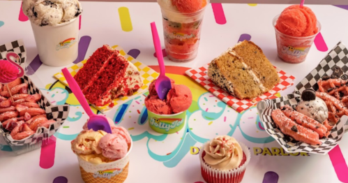 A colorful display of various ice cream treats, including cups, cakes, and cones, on a vibrant patterned table.