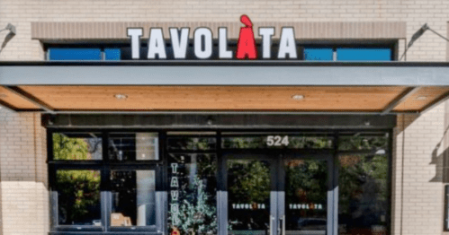 Exterior of Tavolàta restaurant, featuring a modern design and large windows, with the name prominently displayed above the entrance.