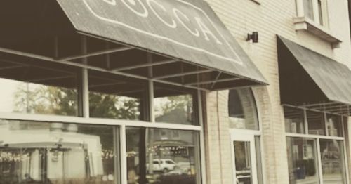 Exterior of a restaurant with a sign reading "BOCCA" and large windows, featuring a canopy and awnings.
