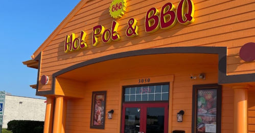 Exterior of a vibrant orange restaurant named "Hot Pot & BBQ," featuring a welcoming entrance and bright signage.