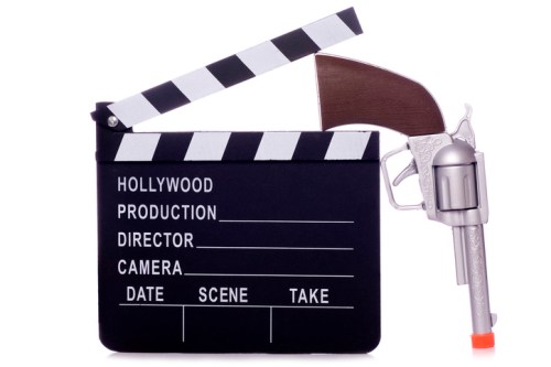 A film clapperboard with a toy revolver, symbolizing a playful take on movie production.