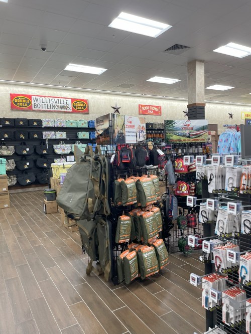 Interior of a retail store showcasing outdoor gear, clothing, and accessories on display shelves.
