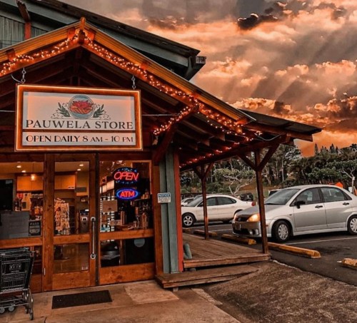 A charming store with a wooden entrance, bright lights, and an "Open" sign, set against a dramatic sky.