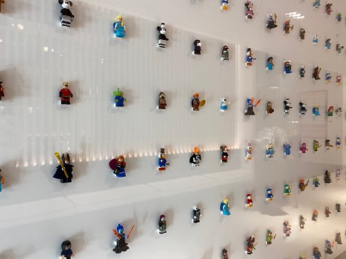 A wall display featuring a variety of colorful LEGO minifigures arranged in rows.