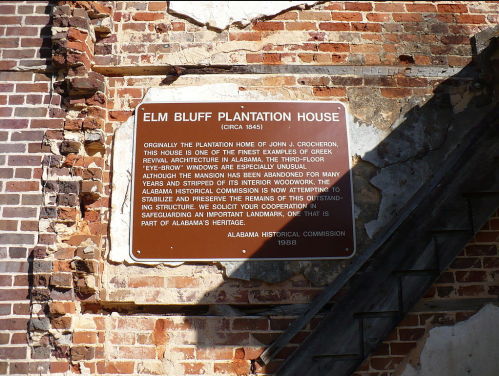 Sign for Elm Bluff Plantation House, detailing its history and architectural significance, mounted on a brick wall.