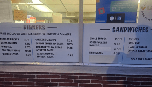 Menu board displaying dinner and sandwich options with prices, including chicken, shrimp, and fish dishes.