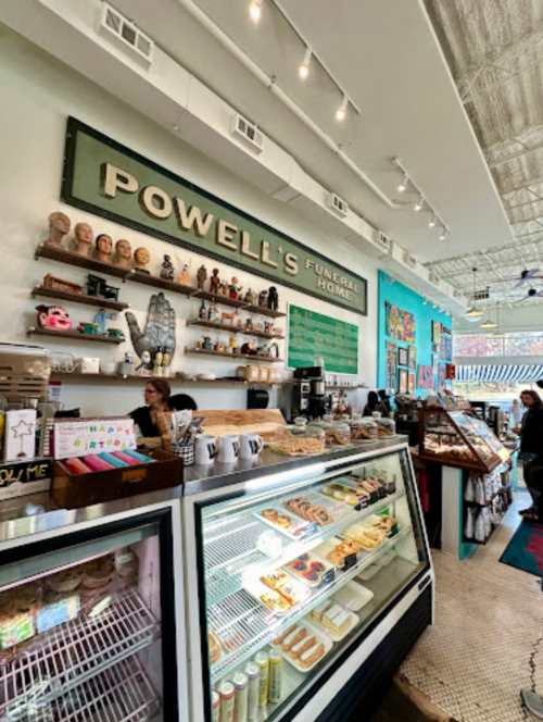 Interior of Powell's Funeral Home, featuring a café area with baked goods, colorful decor, and a display case.