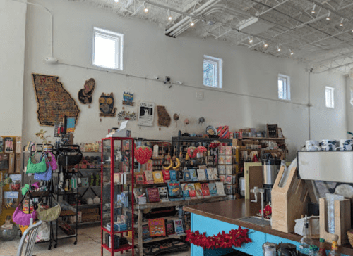 A colorful shop interior filled with various products, books, and decorative items, featuring a bright, airy atmosphere.