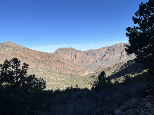 A scenic view of a mountainous landscape with rocky terrain and clear blue skies.