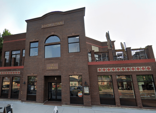 Exterior view of a brick building labeled "Coal Park" with a balcony and outdoor seating area.