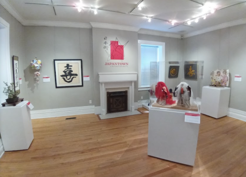 Art gallery featuring Japanese cultural exhibits, including calligraphy, sculptures, and a decorative display.