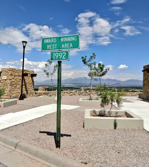Sign for an award-winning rest area from 1992, with mountains and blue sky in the background.