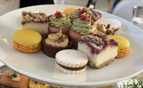 A platter of assorted desserts, including cupcakes, macarons, and layered cakes, beautifully arranged.
