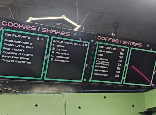 Menu board displaying cookie and shake options, including flavors and prices, with a section for coffee and extras.
