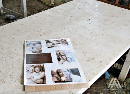 A weathered table with a collage of black-and-white photos featuring smiling people.