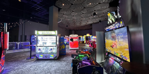 A vibrant arcade filled with various gaming machines and colorful lights, featuring a modern design and spacious layout.