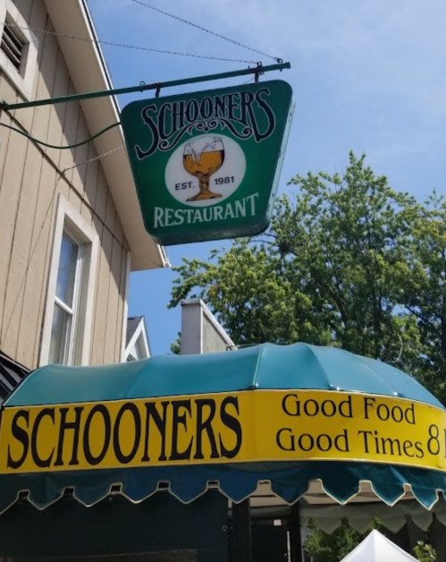 Sign for Schooners Restaurant, established in 1981, featuring a green awning with "Good Food, Good Times."