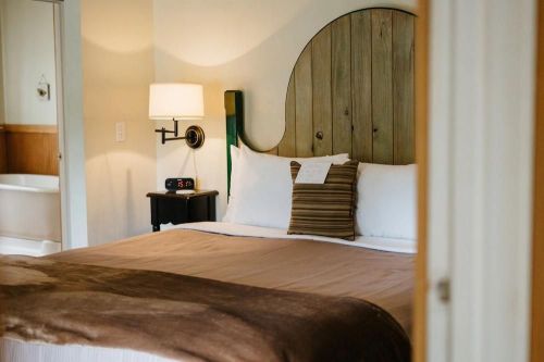 Cozy bedroom featuring a wooden headboard, plush bedding, and soft lighting, creating a warm atmosphere.