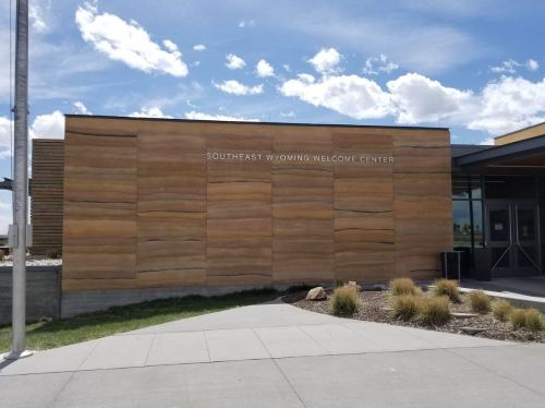 Exterior of the Southeast Wyoming Welcome Center, featuring a wooden facade and clear blue sky.