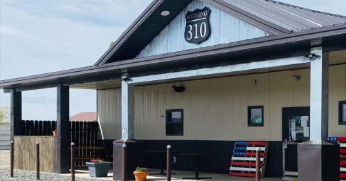 A building with a sign reading "Wyoming 310," featuring a porch and an American flag-themed decoration.