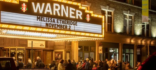 Crowd gathered outside the Warner Theatre, illuminated marquee announcing Melissa Etheridge on November 2.