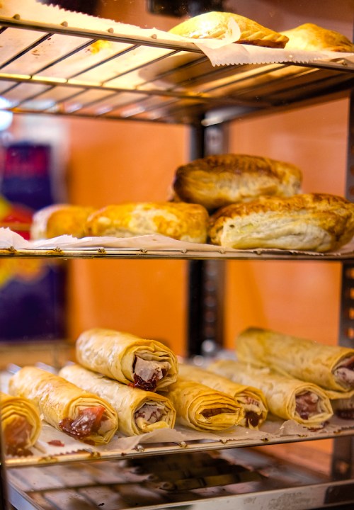 A display case filled with various baked goods, including pastries and rolled snacks.