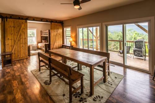 Cozy dining area with a wooden table, chairs, and sliding barn doors, leading to a deck with scenic views.