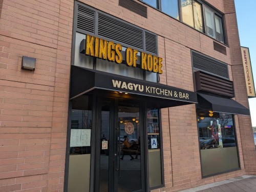 Exterior of "Kings of Kobe" restaurant featuring "Wagyu Kitchen & Bar" sign, with large windows and a modern facade.