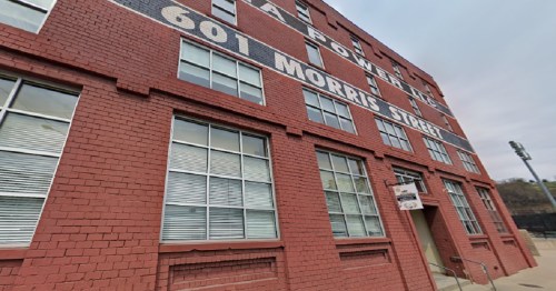 Red brick building with large windows, featuring the address "601 Morris Street" prominently displayed on the facade.