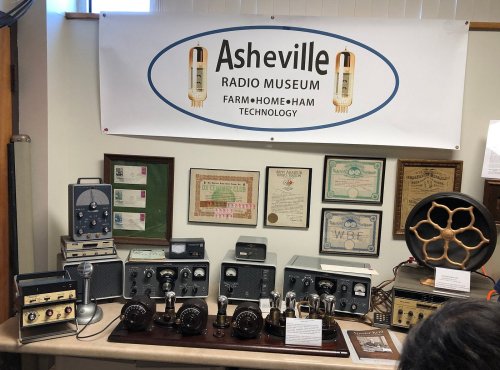 Display of vintage radios and equipment at the Asheville Radio Museum, featuring various models and historical certificates.