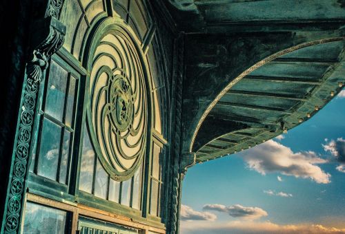 Intricate architectural detail of a building with a circular design and a blue sky in the background.