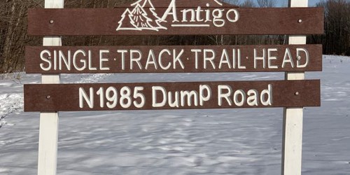 Sign for Antigo Single Track Trail Head on a snowy path, located at N1985 Dump Road.