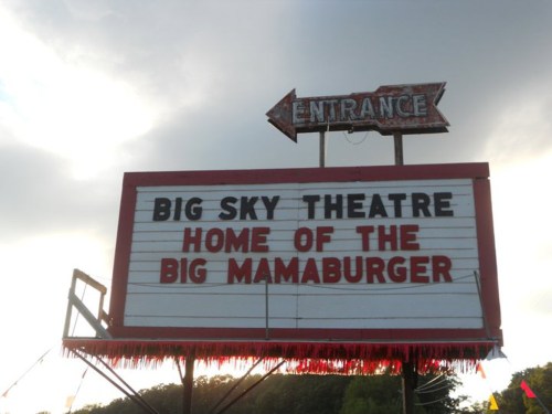 Sign for Big Sky Theatre with an arrow pointing to the entrance, advertising the "Home of the Big Mamaburger."